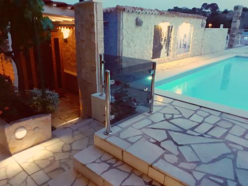 a swimming pool with a fence next to a house at Bluesun Sibenik Apartments in Šibenik
