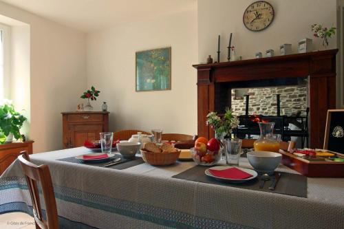 een eetkamer met een tafel met eten erop bij Domaine de l'Etre in Saint-Pierre-du-Regard