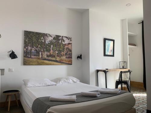 ein Schlafzimmer mit einem Bett und einem Wandgemälde in der Unterkunft Hotel Le Centre in Le Boulou