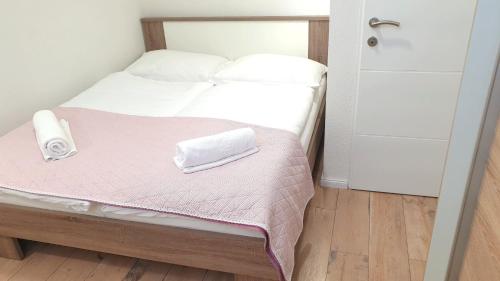 a small bedroom with a bed with a phone on it at Bluesun Sibenik Apartments in Šibenik