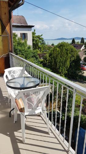 a white table and chairs on a balcony at Szatmári Vendégház in Badacsonytomaj