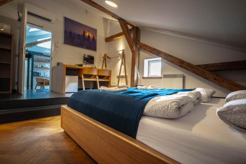 a bedroom with a large bed with blue sheets at Old Town Square Suites Prague in Prague