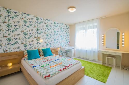 1 dormitorio con 1 cama grande y espejo en Villa Mária Vendégház, en Siófok