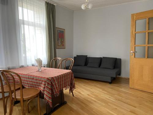 - un salon avec une table et un canapé dans l'établissement Apartamentai Eurista, à Druskininkai