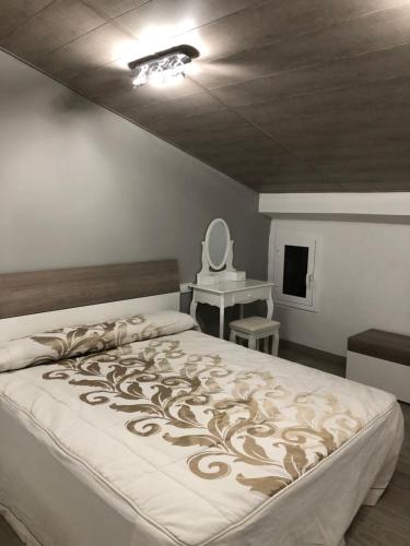 a bedroom with a bed and a table and a mirror at Apartaments els Pins - Sant Hilari Sacalm in Sant Hilari Sacalm