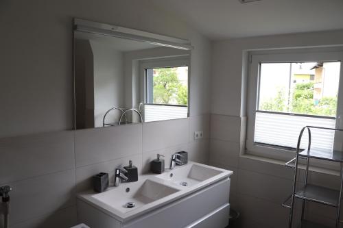 a white bathroom with a sink and a mirror at Apartment DreamView in Drobollach am Faakersee