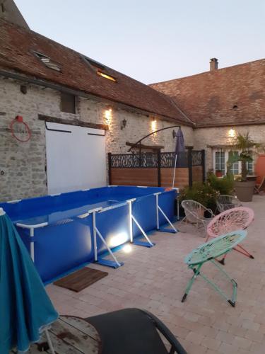a blue table and chairs in front of a building at ancienne maison des templiers in Gouillons