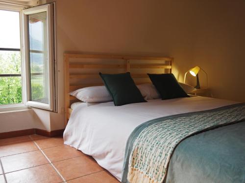 a bedroom with a large bed and two windows at Open Cascina in Colico
