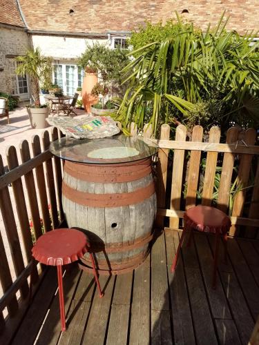a barrel table and two chairs on a deck at ancienne maison des templiers in Gouillons