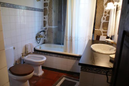 a bathroom with a toilet and a sink and a tub at Casa Da Quinta Do Rei in Ponte de Lima