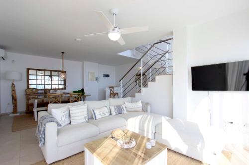 a living room with a white couch and a table at Can Lou-Casa con Caracter en Cullera in Faro de Cullera