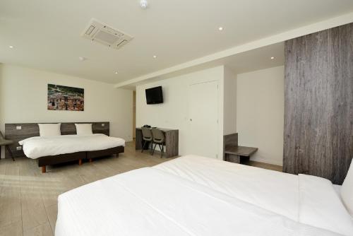 a hotel room with two beds and a tv at The Market by Parkhotel in Kortrijk