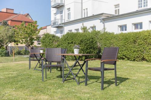 un grupo de sillas y una mesa en el césped en Villa Vineta, en Kühlungsborn