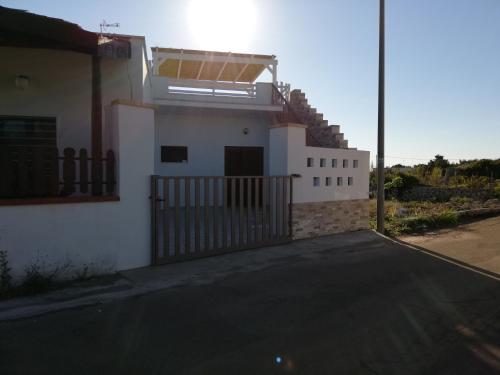 a white house with a gate and a driveway at Casa vacanze SALENTO BELLA VISTA in Capilungo