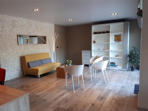 een woonkamer met een bank en een tafel en stoelen bij Au Paradis Guesthouse in Waregem