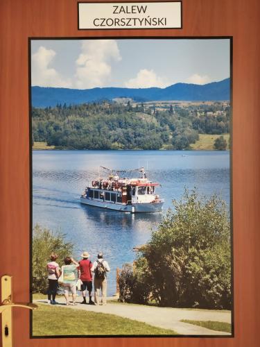 a large boat on a lake with people on it at Arenda Noclegi Niedzica in Niedzica