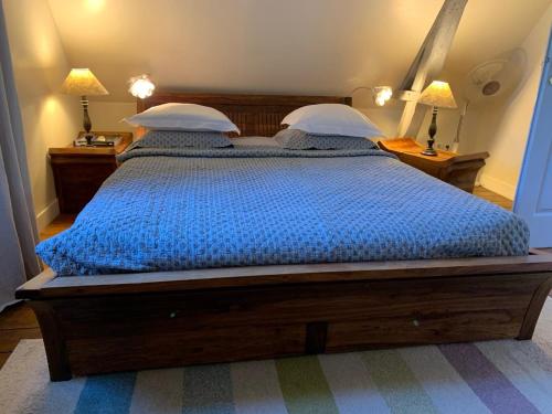 a bedroom with a bed with a blue comforter and two lamps at Chambres d'Hôtes Villa Mon Repos in Saint-Aubin-sur-Scie