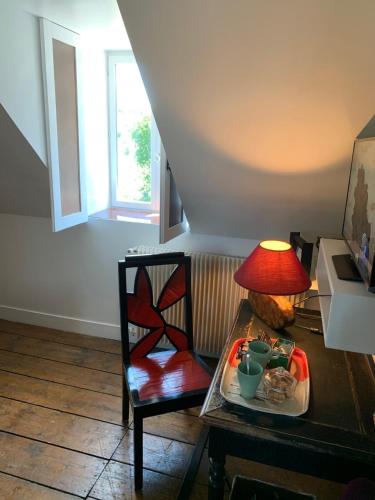 a table with a plate of food and a lamp at Chambres d'Hôtes Villa Mon Repos in Saint-Aubin-sur-Scie