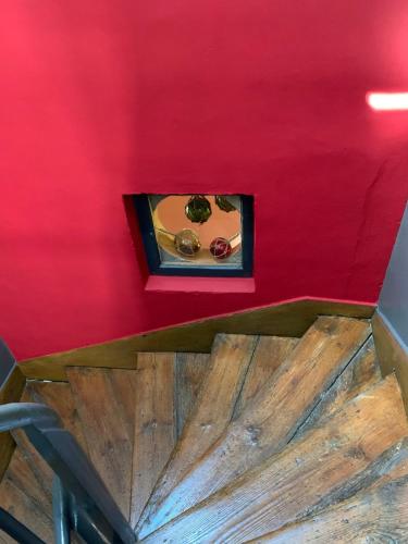 a room with a red wall and a wooden table at Chambres d'Hôtes Villa Mon Repos in Saint-Aubin-sur-Scie