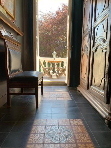 a room with a chair and an open door at Chambres d'Hôtes Villa Mon Repos in Saint-Aubin-sur-Scie
