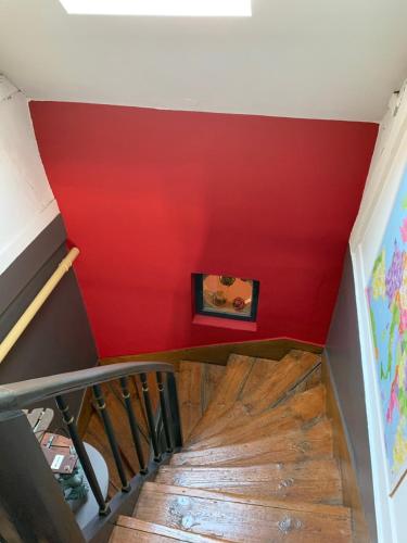 a staircase with red walls and a red wall at Chambres d'Hôtes Villa Mon Repos in Saint-Aubin-sur-Scie