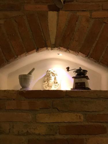 a statue on a brick wall with a light at Casale Vincenzo Country House in Collecorvino