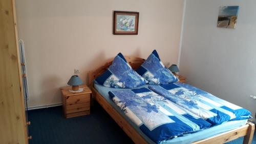 1 dormitorio con 1 cama con sábanas azules y almohadas azules en Ferienhaus Monika, en Mursewiek
