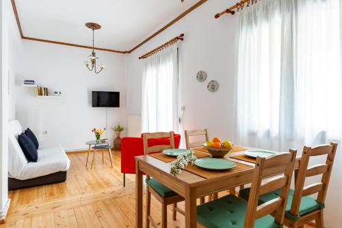 a kitchen and living room with a wooden table and chairs at Cath's Guesthouse in Skopelos Town