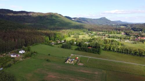 an aerial view of a green field with a house at Domki pod Derkaczem in Wünschelburg