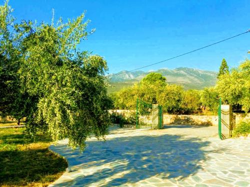 ein Tor in einem Hof mit Bergen im Hintergrund in der Unterkunft Villa Pefnos in Agios Nikolaos