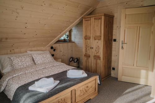 a bedroom with a bed with two towels on it at Szałas Kosówka in Witów