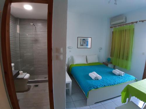 a bedroom with a bed and a bathroom with a shower at Rappos Studios in Kallithea Halkidikis