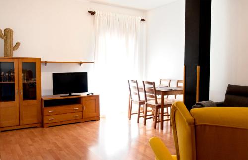 sala de estar con TV y mesa con sillas en Apartamento Cactus Centro, en Úbeda