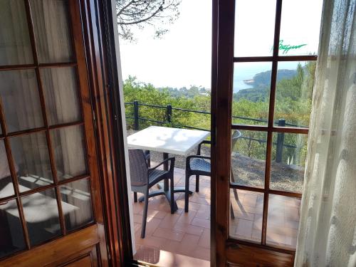 Habitación con balcón con mesa y sillas. en Hostal Sa Barraca - Adults Only en Begur