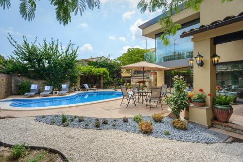 d'une terrasse avec une table et des chaises à côté de la piscine. dans l'établissement Casa Deluxe Alt Empordà Costa Brava - Private swimming pool, à Vilabertrán
