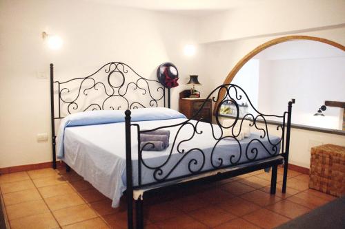 um quarto com uma cama com uma moldura em ferro forjado em Daniela House em Santa Teresa di Riva