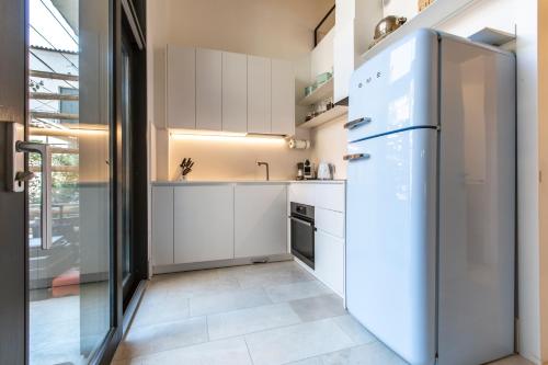  La cuisine est équipée de placards blancs et d'un réfrigérateur. dans l'établissement Casa Della Gondola R&R, à Venise
