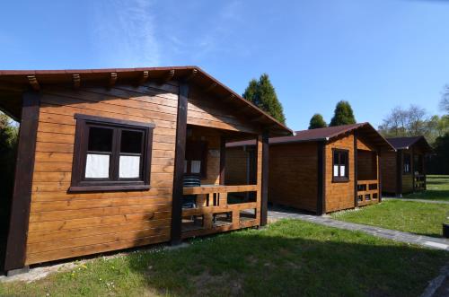a log cabin with a porch and a fence at Camping Villaviciosa in La Rasa Selorio