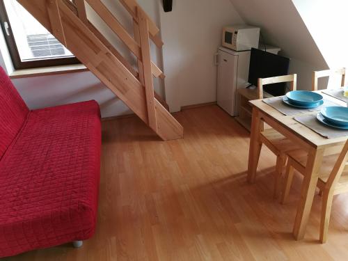 a living room with a red couch and a dining room table at Apartmány Dolní Moravice in Dolní Moravice