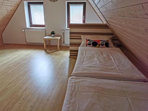 a large bed in a room with two windows at Apartmány Dolní Moravice in Dolní Moravice