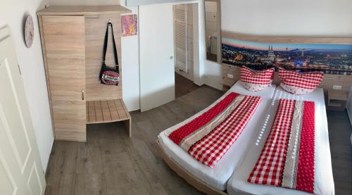 - une chambre avec un lit doté d'oreillers rouges et blancs dans l'établissement Abtei Apartment Brauweiler, à Pulheim