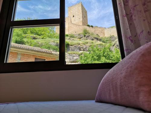 ein Schlafzimmer mit einem Fenster mit Blick auf eine Burg in der Unterkunft Salvatierra in Cazorla