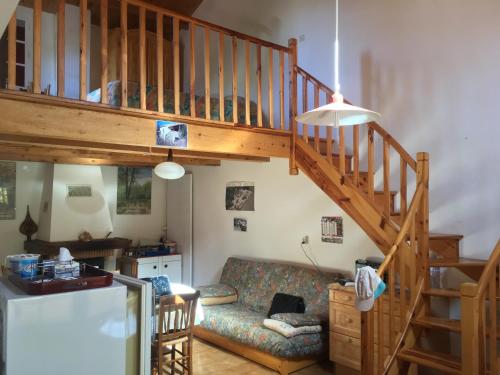 a living room with a staircase and a couch at Jolie petite maison dans hameau en pleine nature in Taussac-la-Billière