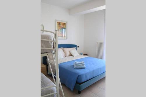 una camera con letto a castello e coperta blu di Appartamento delle Vele a Bellaria-Igea Marina