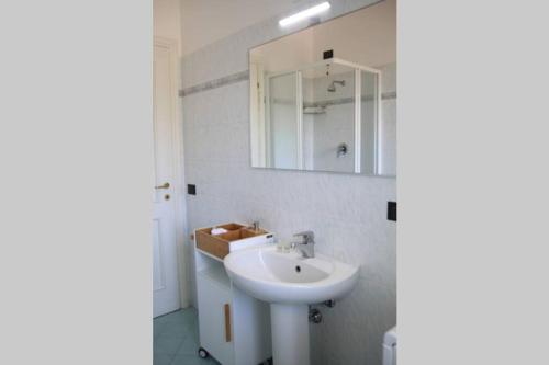 bagno bianco con lavandino e specchio di Appartamento delle Vele a Bellaria-Igea Marina