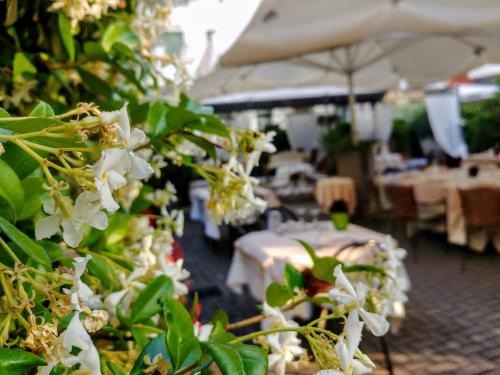 a group of white flowers in a room with tables at Hotel Locanda Al Sole in Castello di Godego