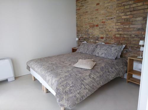 a bedroom with a bed with a brick wall at La Casa di Tara B&B Armonia e Natura in Recanati