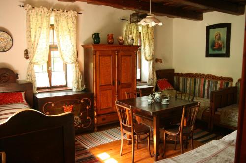 a dining room with a table and a bedroom at Cserépmadár szállás és Csinyálóház in Velemér