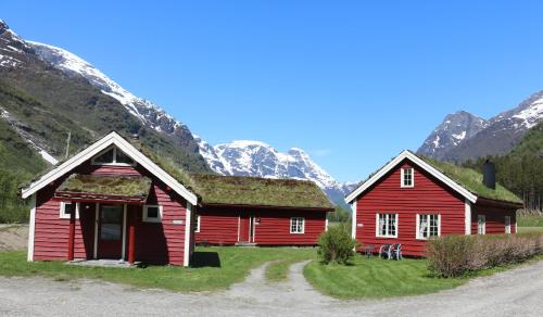 due fienili rossi con erba sul tetto di fronte alle montagne di Trollbu Aabrekk gard a Briksdalsbre