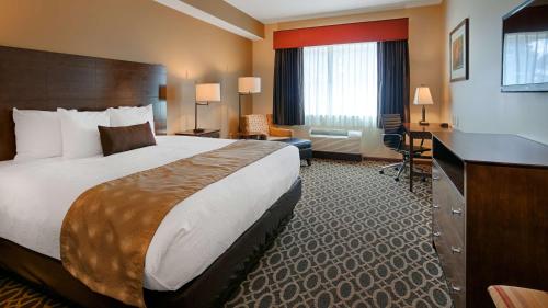 een hotelkamer met een groot bed en een bureau bij Best Western Paradise Inn in Savoy